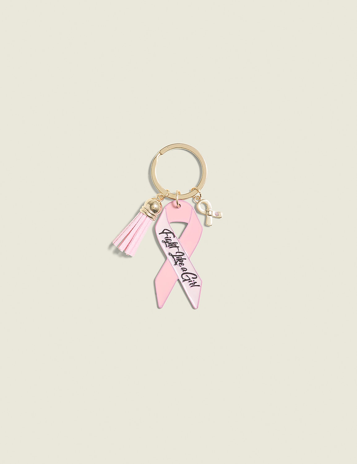 A pink breast cancer awareness ribbon keychain with a tassel and a small ribbon charm hangs against a plain, light beige background. Product Image 1