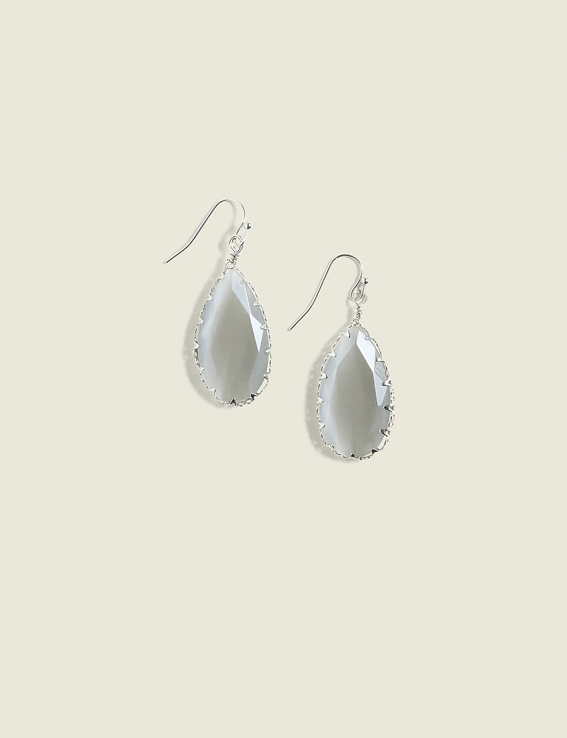 A pair of teardrop-shaped gray gemstone earrings with silver settings hang against a plain, light beige background. Product Image 1
