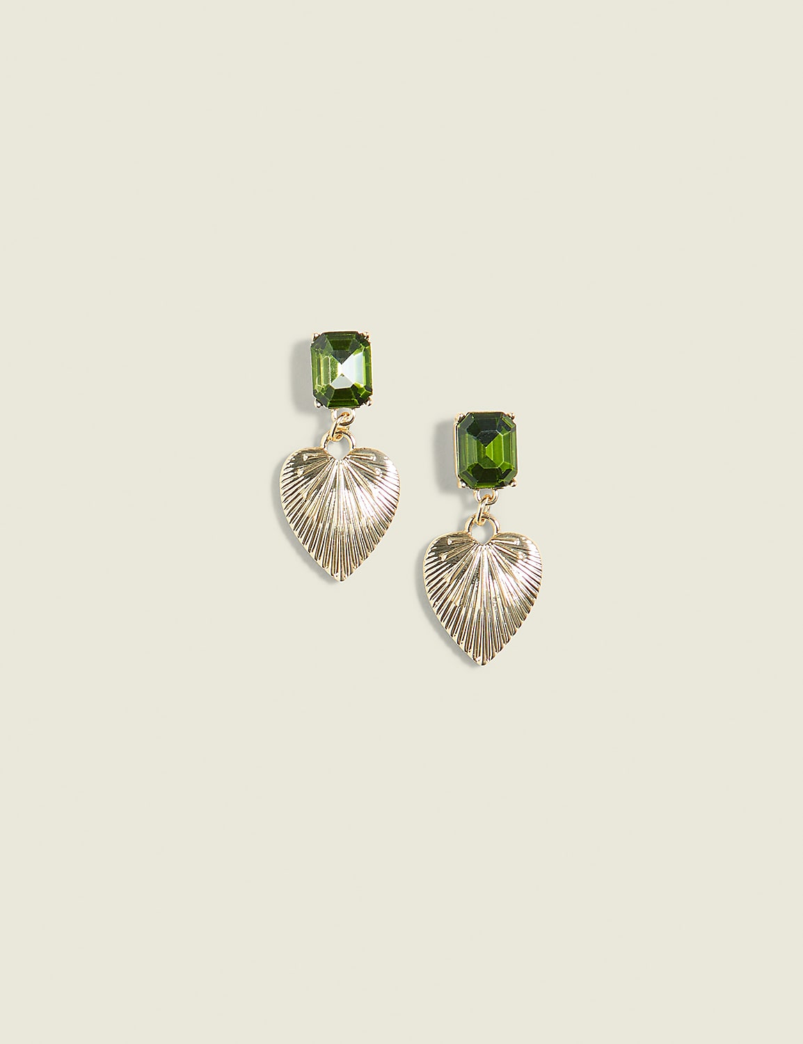 A pair of gold heart-shaped earrings with green gemstone tops hang against a plain, light beige background. Product Image 1
