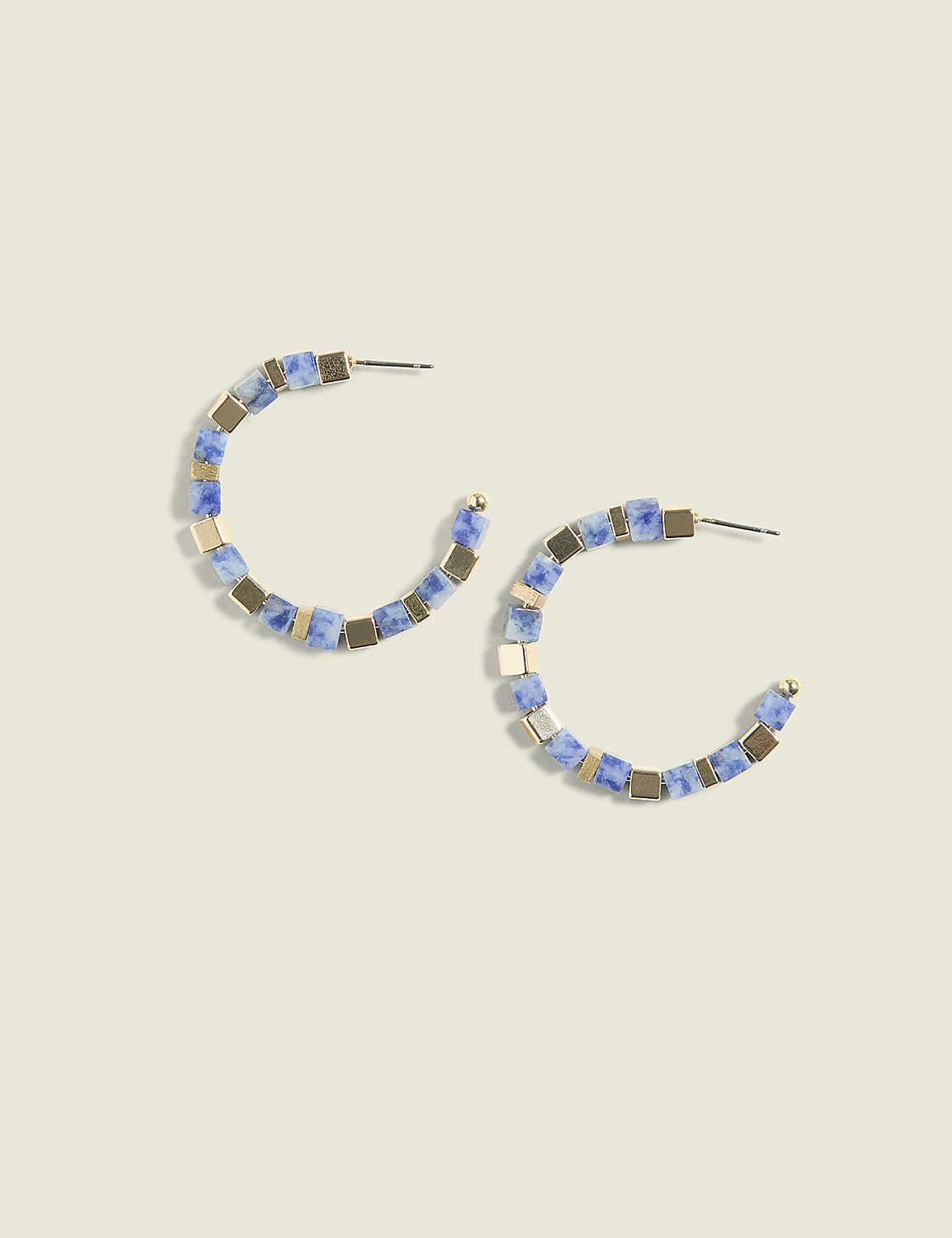 A pair of blue and gold beaded hoop earrings rests on a pale green background. Product Image 1