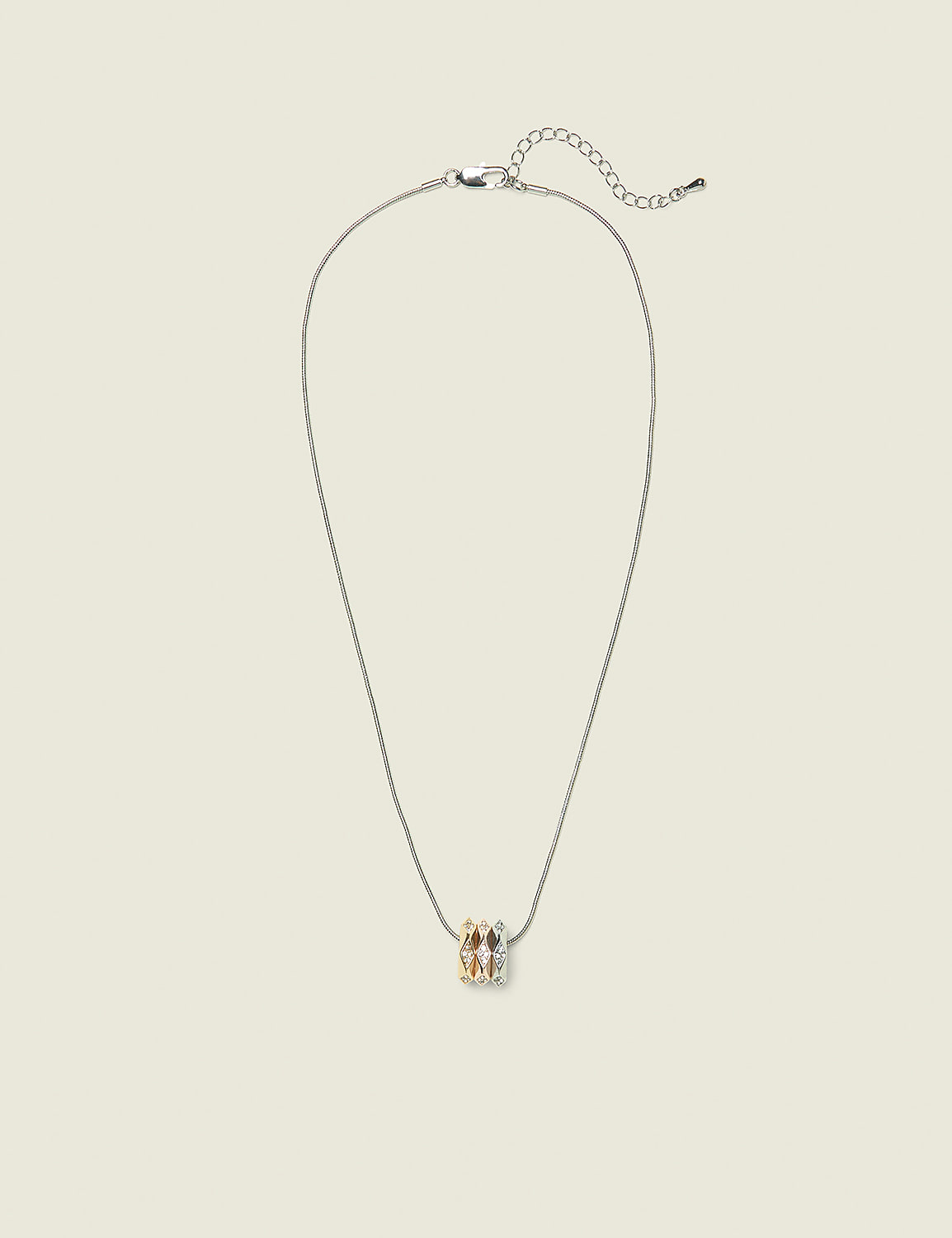 A delicate silver necklace with a cluster of sparkling gemstones hangs against a plain, light-colored background. Product Image 1