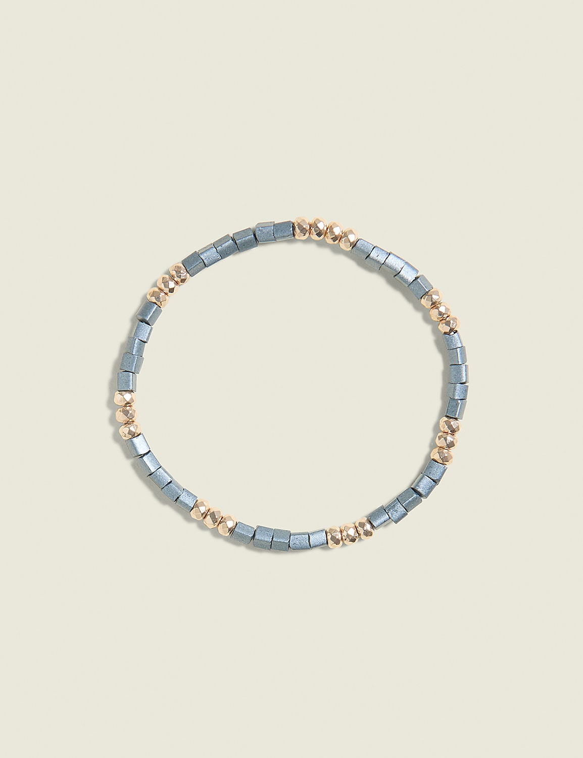 A bracelet of gray and gold beads is centered on a pale yellow background. Product Image 1
