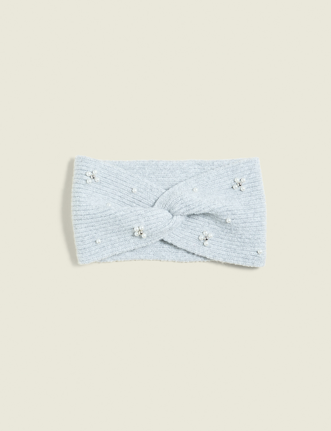 A light blue, fuzzy headband with a twisted knot and scattered pearl and rhinestone embellishments rests on a pale blue background. Product Image 1