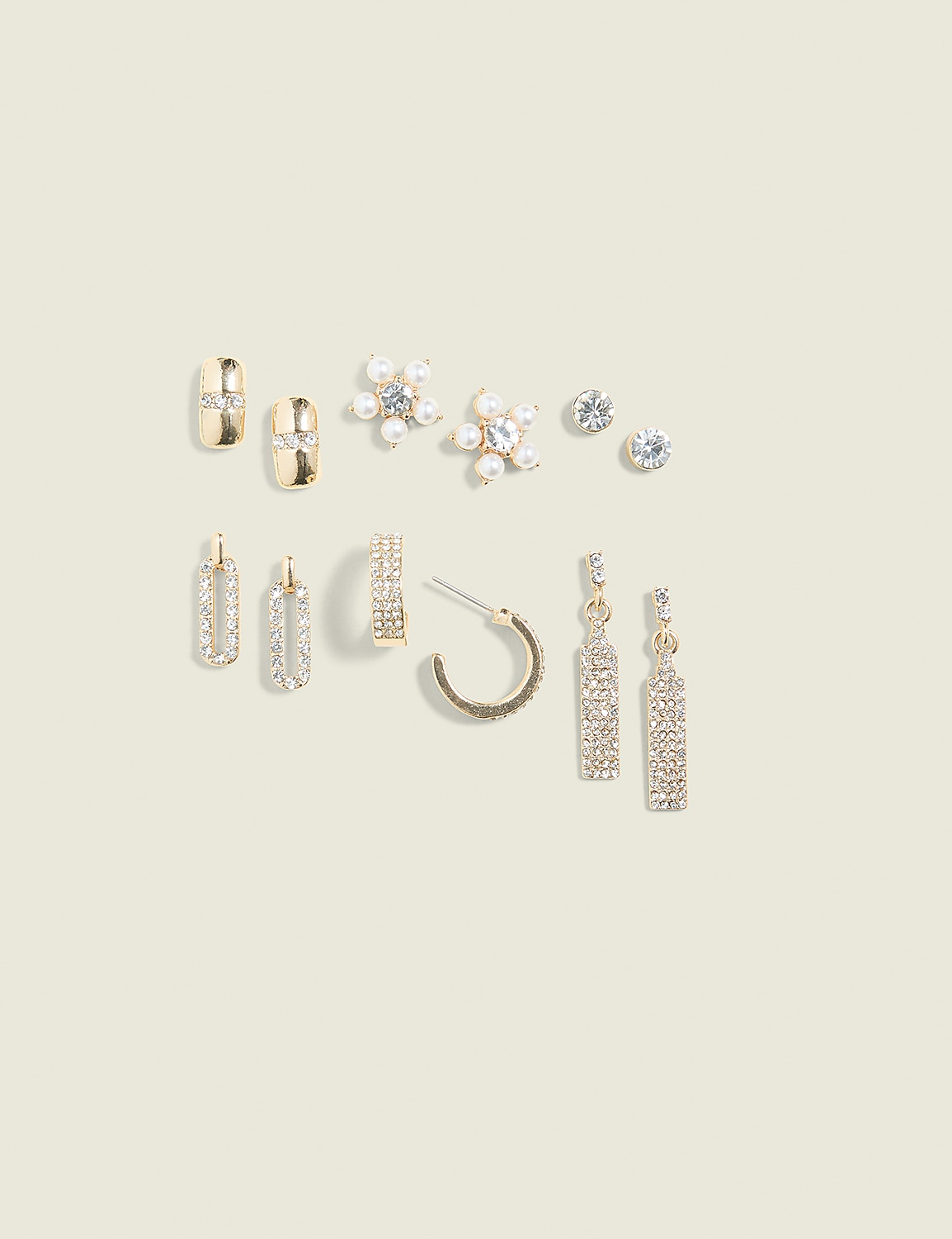 A collection of gold and silver earrings, some with rhinestones and pearls, are arranged on a pale yellow background. Product Image 1