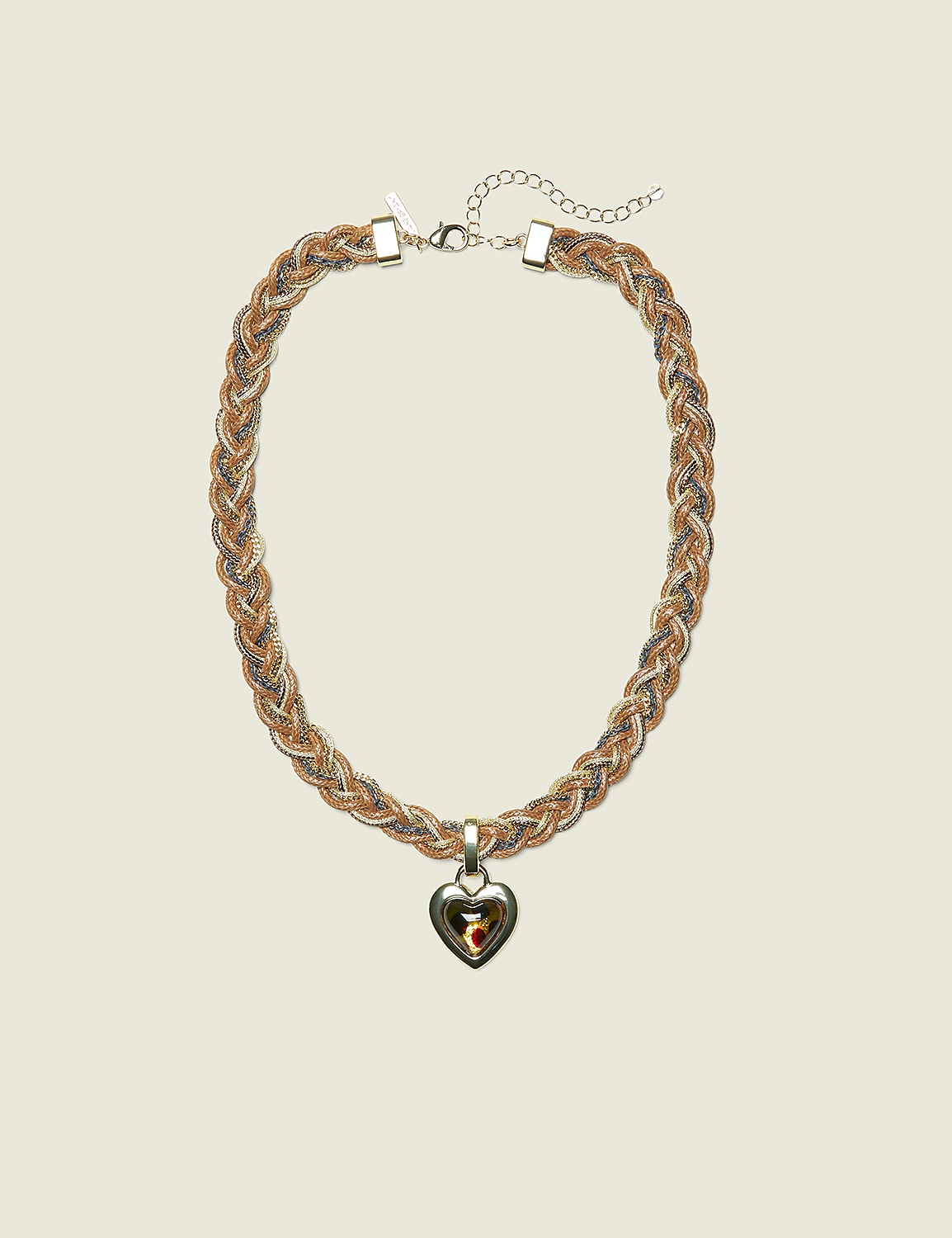 A braided gold and silver necklace with a heart-shaped pendant rests against a plain, light-colored background. Product Image 1