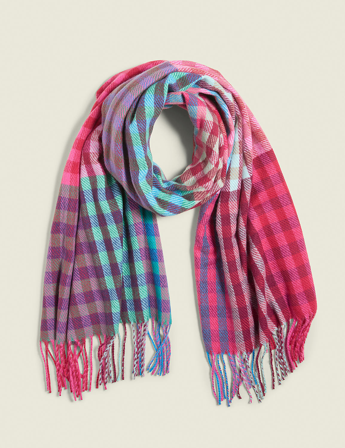 A colorful, plaid scarf with fringed ends is laid out against a plain, light-colored background. Product Image 1