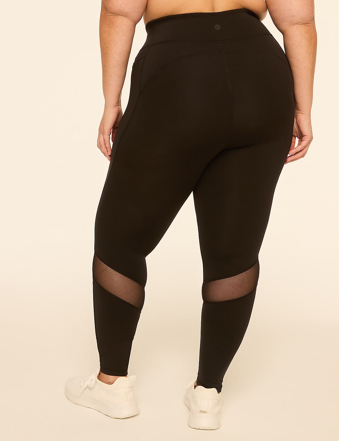 A person wearing black leggings with mesh inserts on the calves stands against a plain, light-colored background. Product Image 2