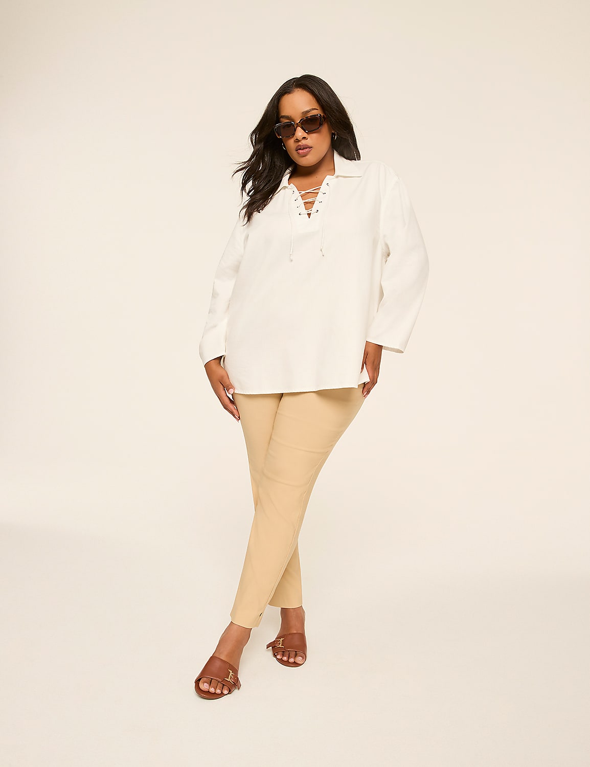 A woman in a white lace-up top and tan pants poses against a plain, light-colored background. Product Image 6