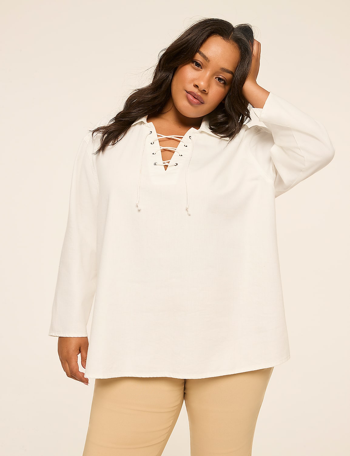A woman in a white lace-up shirt and tan pants poses against a plain, light-colored background. Product Image 8