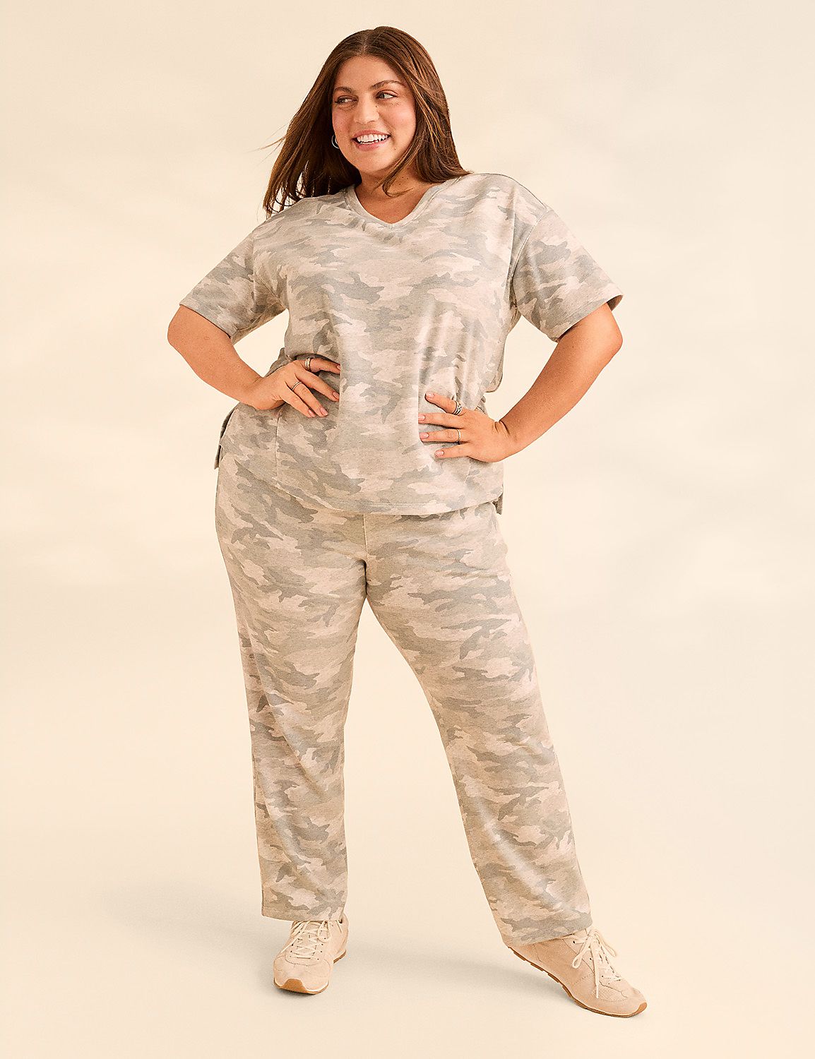 A woman in a camouflage loungewear set stands with her hands on her hips against a plain, light-colored background. Product Image 4