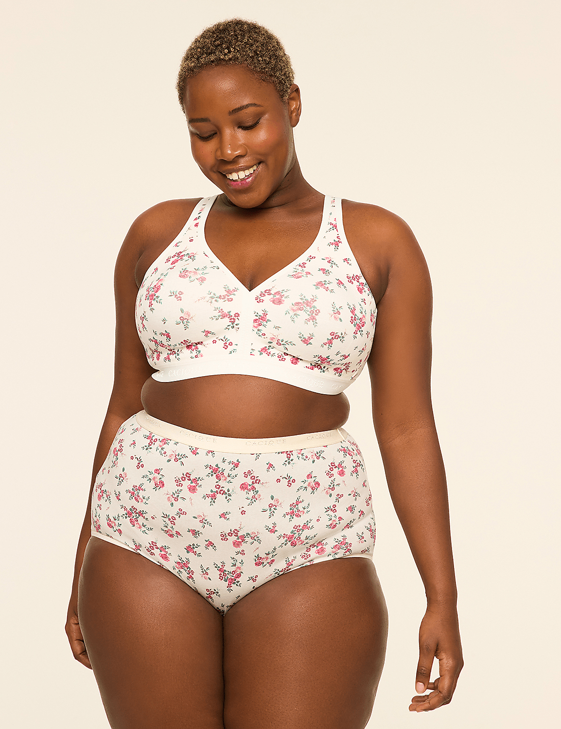A smiling woman in a floral bra and matching underwear stands against a plain, light-colored background. Product Image 4