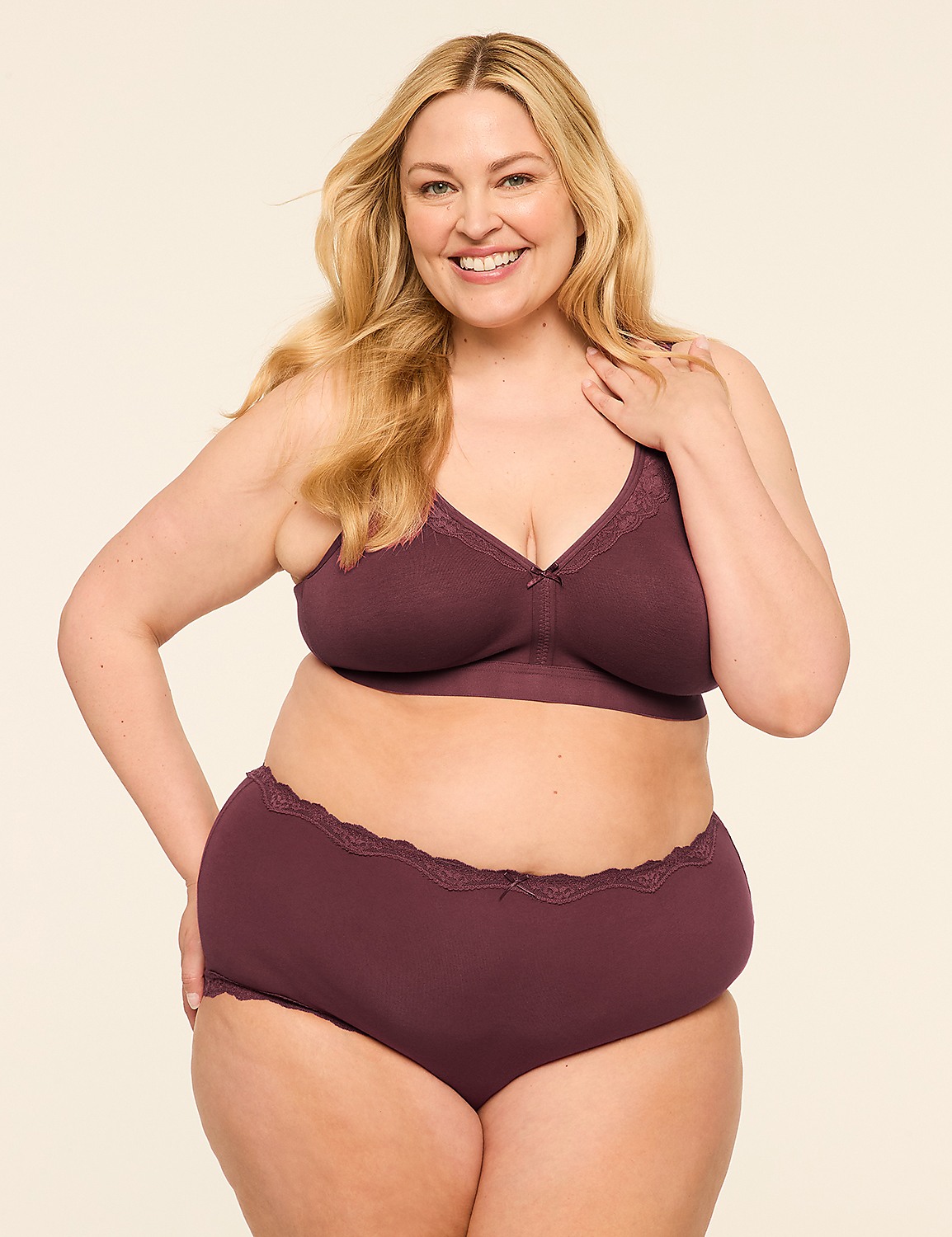 A smiling, plus-size woman in a plum-colored bra and underwear stands against a plain, light-colored background. Product Image 4