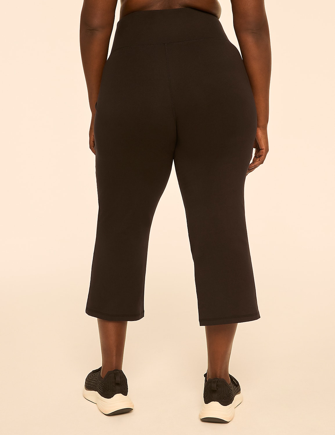 A person wearing black capri leggings and sneakers stands against a plain, light-colored background. Product Image 2