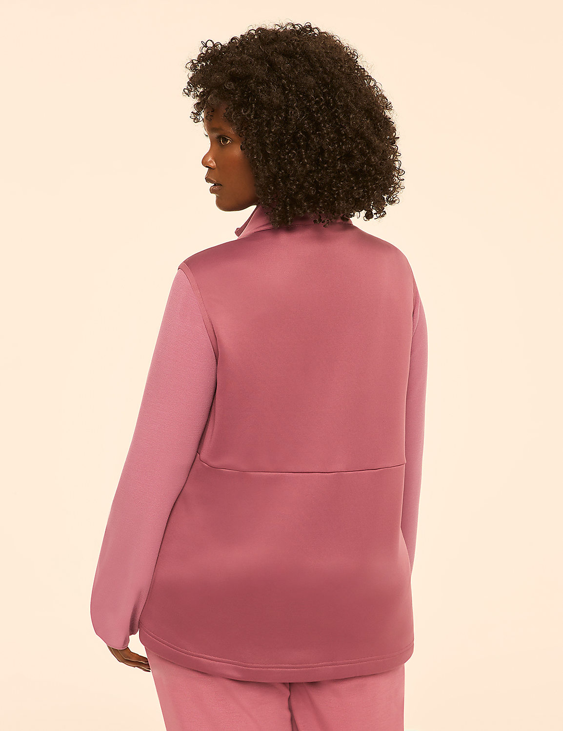 A woman with dark curly hair stands facing away from the camera, wearing a mauve jacket and pants against a plain, light-colored background. Product Image 2