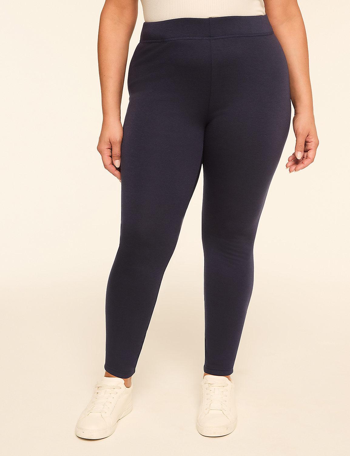 A person wearing navy blue leggings and white sneakers stands against a plain, light-colored background. Product Image 1