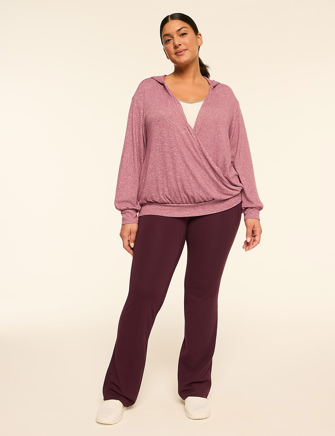 A woman in a mauve wrap hoodie and plum flared pants stands against a plain cream background. Product Image 3