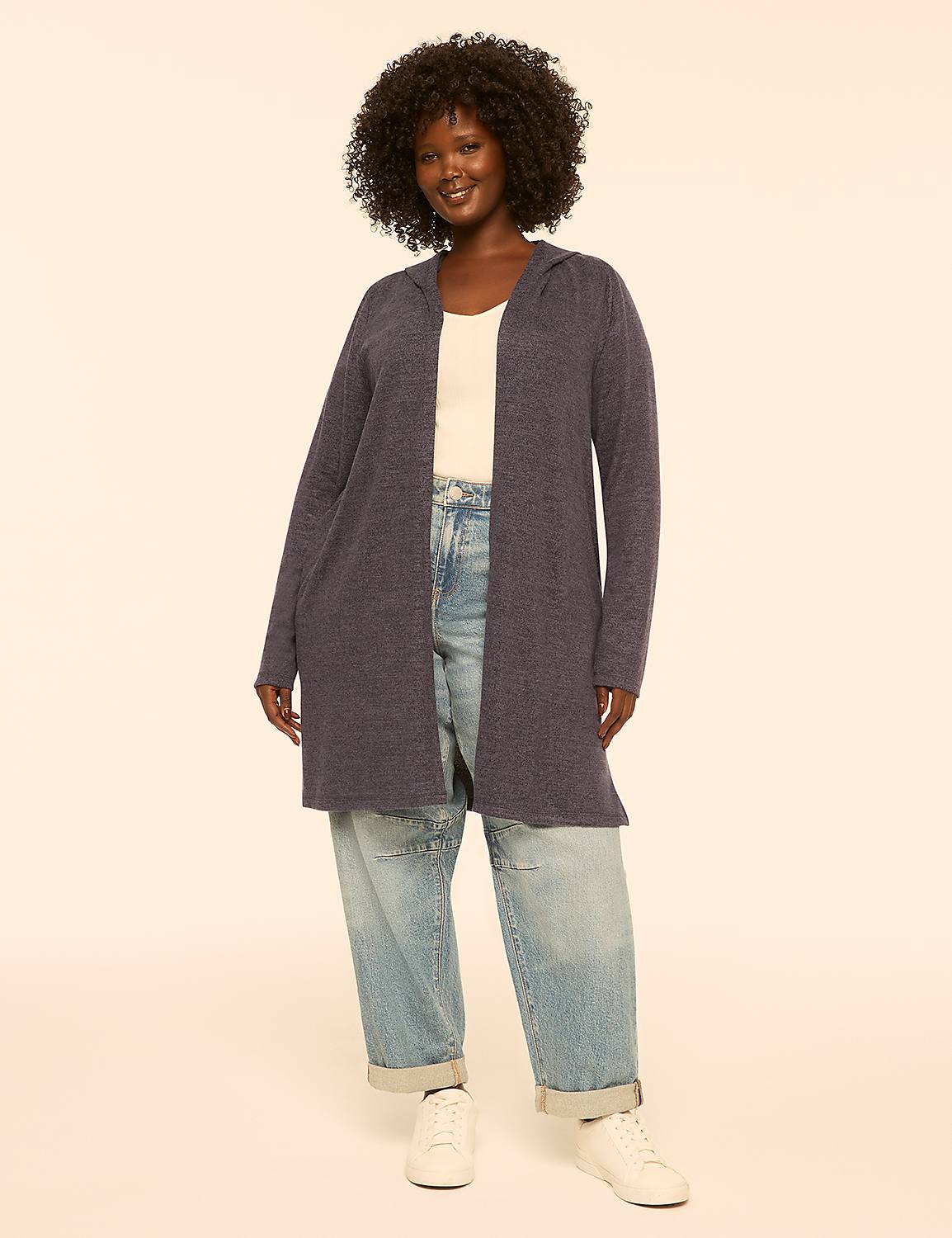 A woman in a blue cardigan stands against a plain, light-colored background. Product Image 1