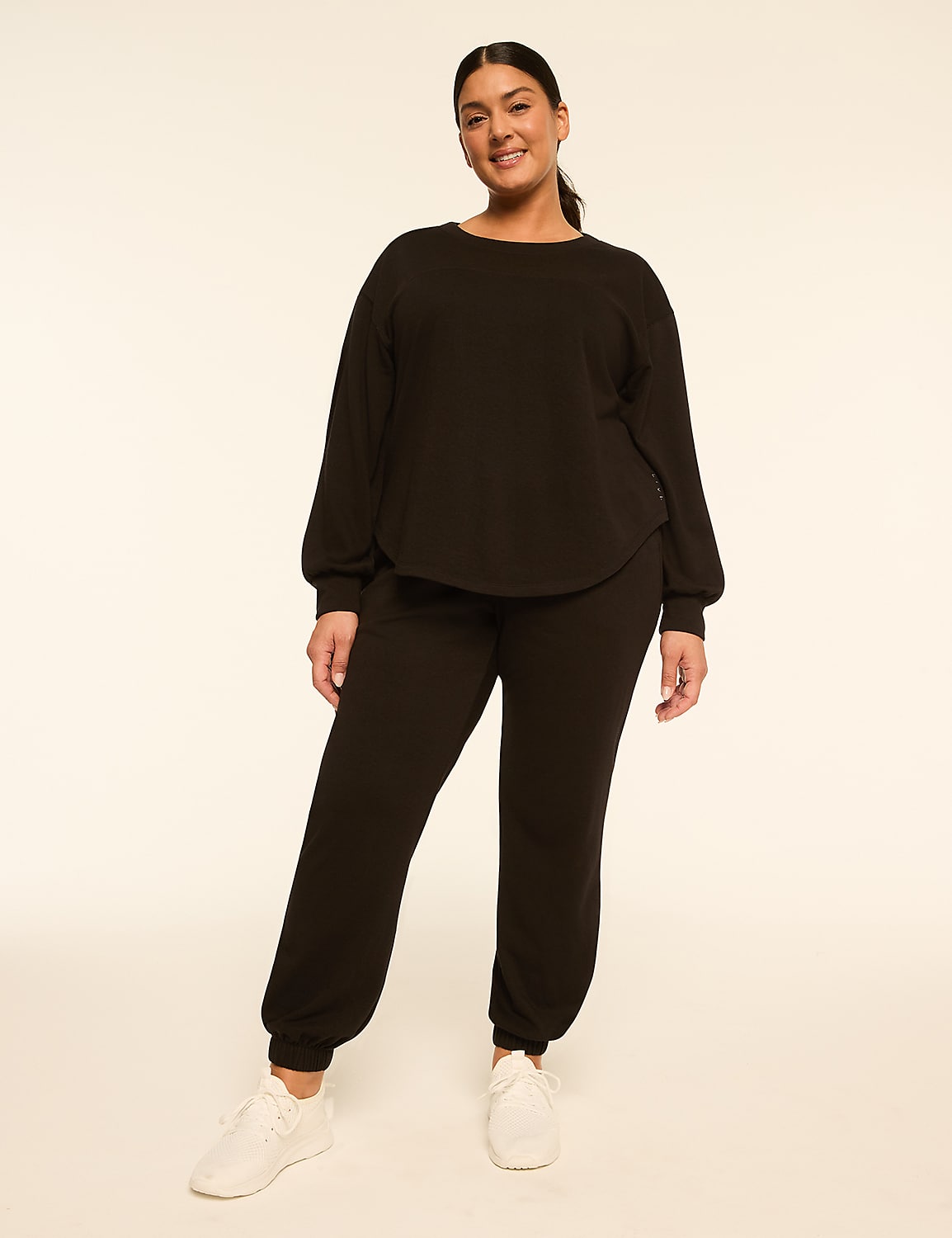 A woman in a black loungewear set and white sneakers stands against a plain, light-colored background. Product Image 3