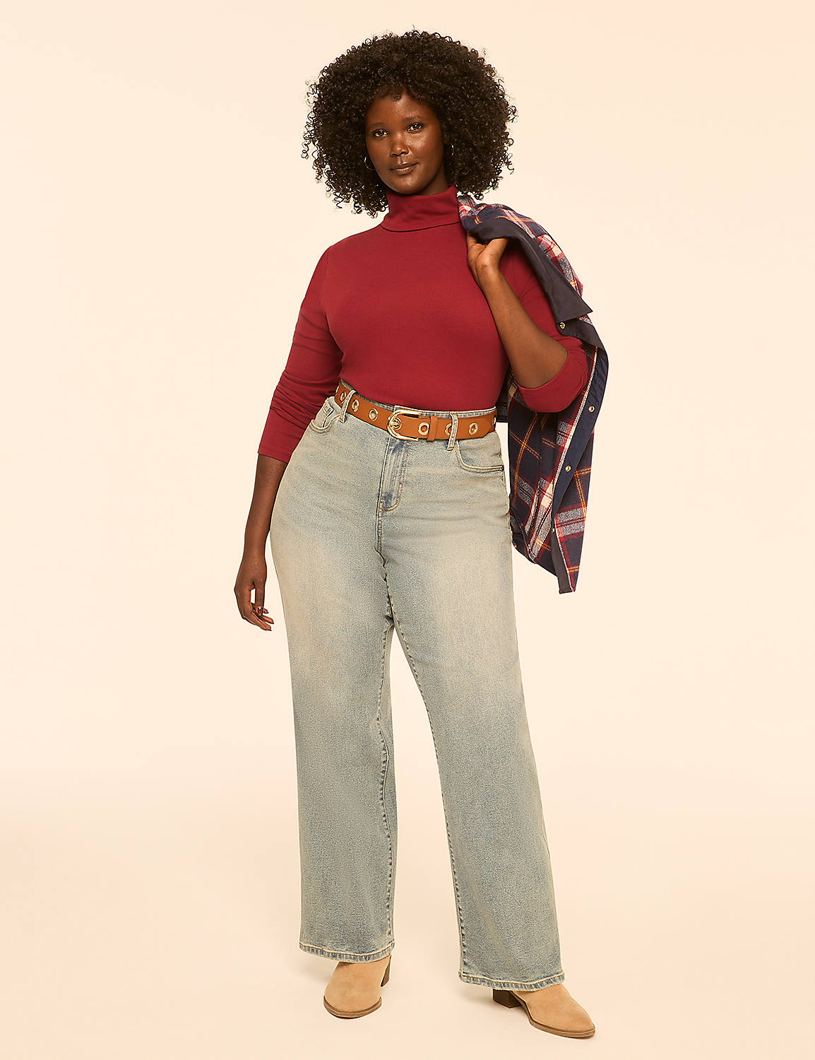 A woman in a maroon turtleneck and light-wash jeans stands against a plain, light-colored background, a plaid jacket draped over her shoulder. Product Image 3