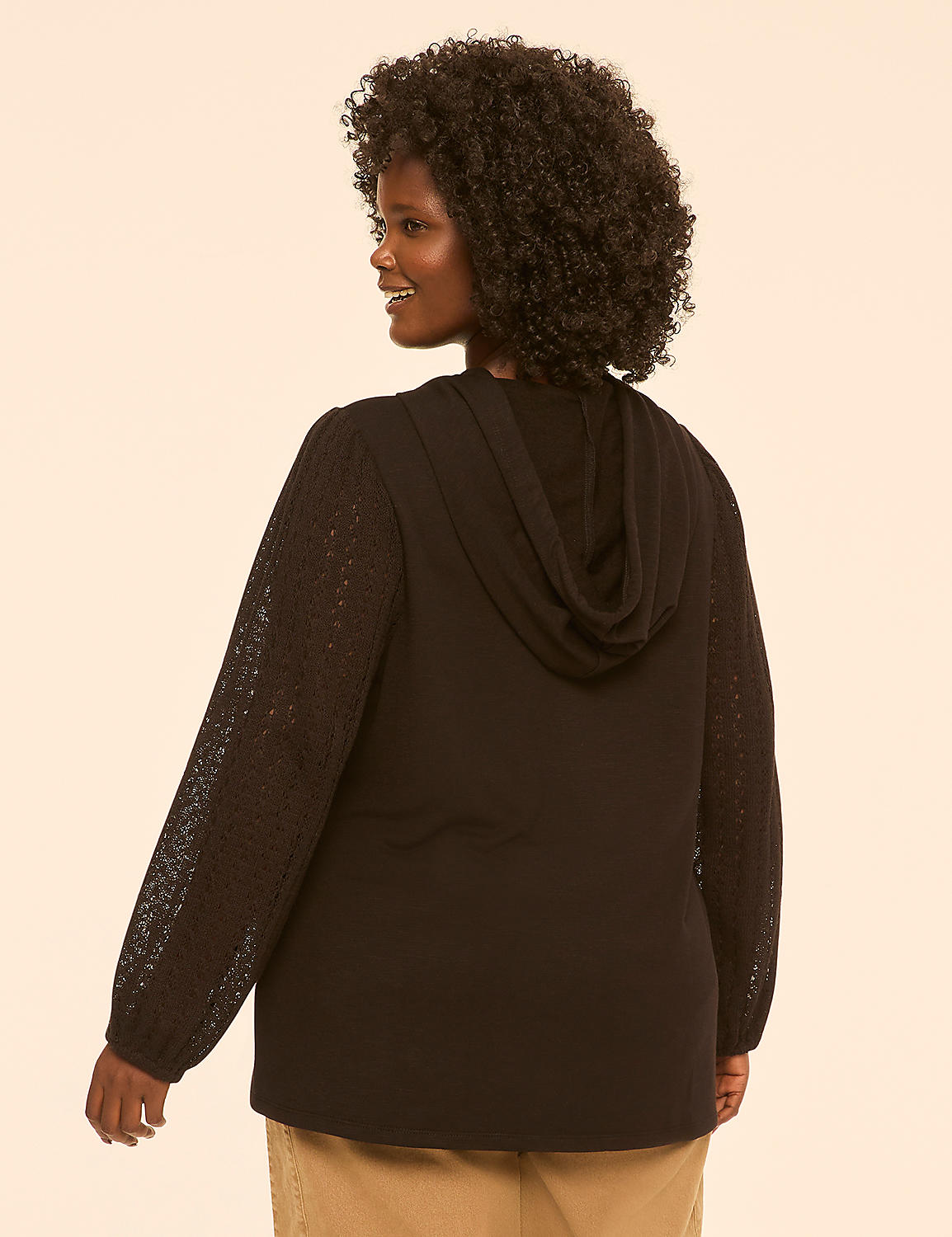 A woman with curly hair wears a black hooded sweatshirt with lace sleeves, standing against a plain, light-colored background. Product Image 2
