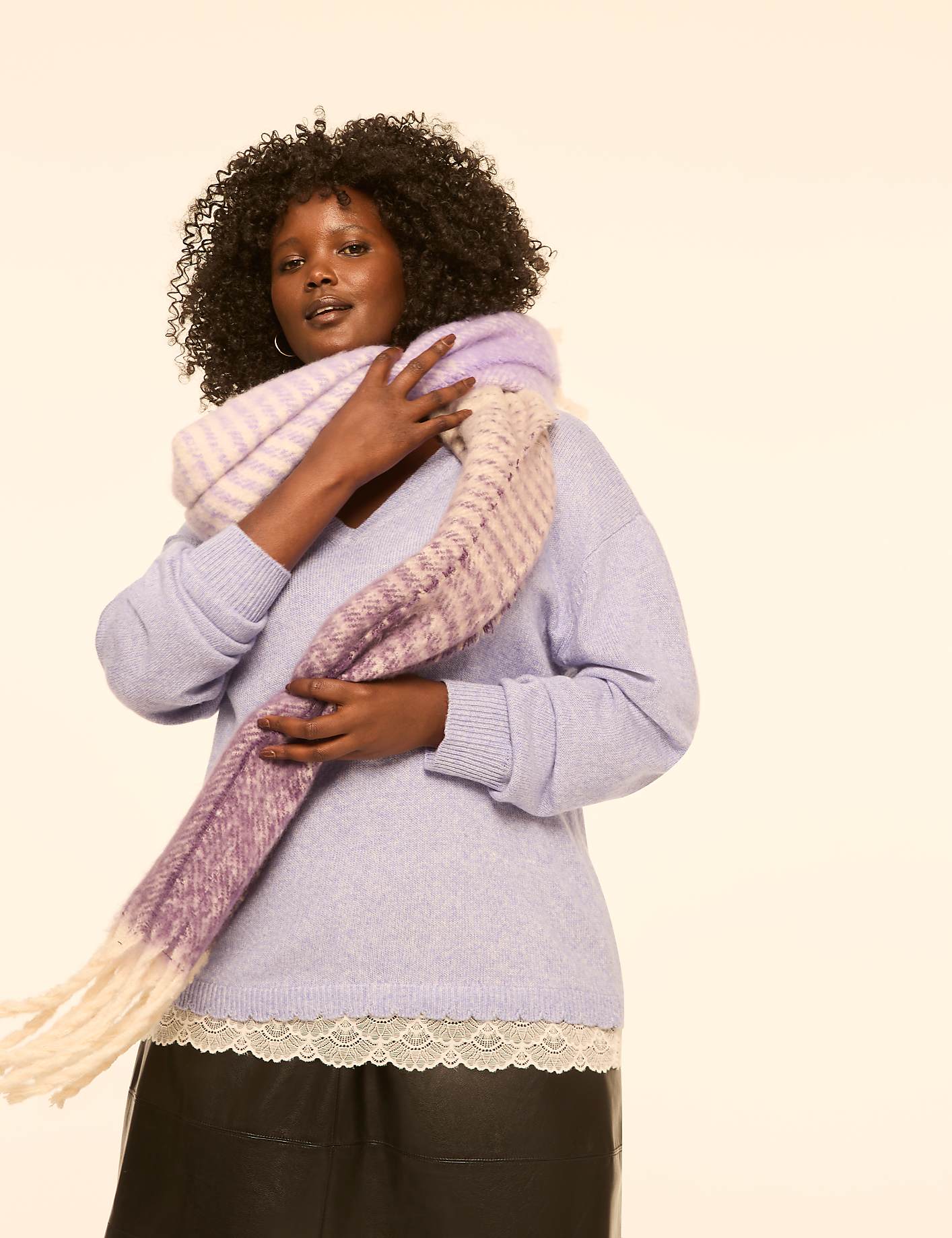 A woman in a lavender sweater and a striped scarf stands against a plain cream background. Product Image 5