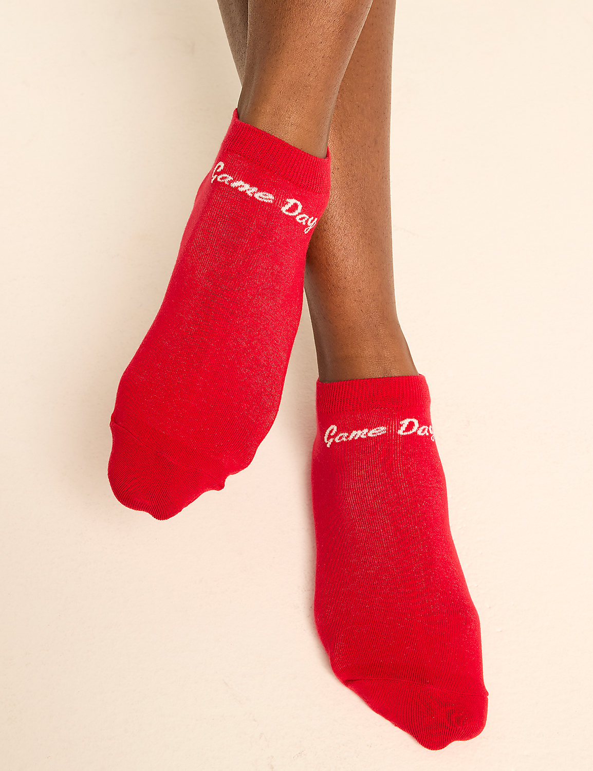 A pair of red ankle socks with "Game Day" written on them are shown against a plain, light-colored background. Product Image 3