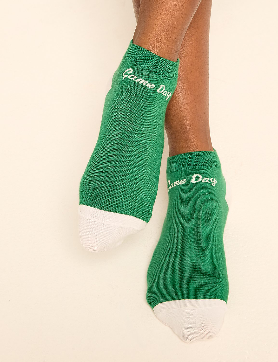 Green "Game Day" socks with white toes are shown against a plain, light-colored background. Product Image 1