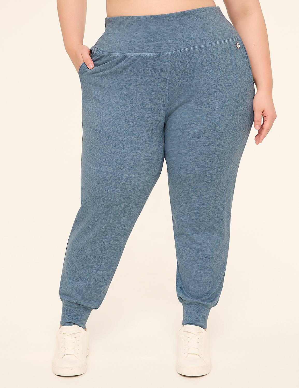 A person wearing blue heathered joggers with white sneakers stands against a plain cream background. Product Image 1