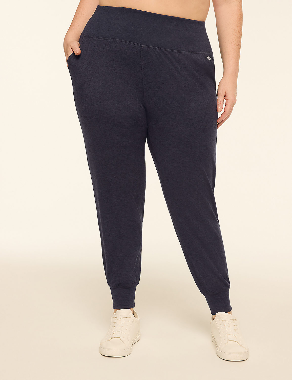 A person wearing dark grey joggers and white sneakers stands against a plain, light-colored background. Product Image 1