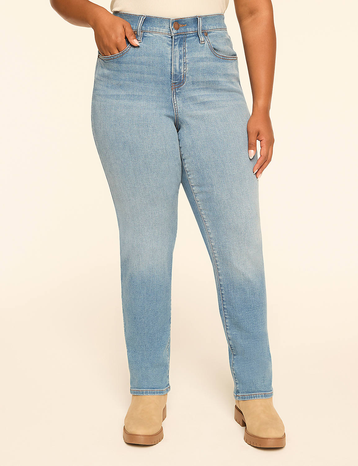 A woman with long dark hair and hoop earrings stands in the foreground wearing a navy v-neck shirt and jeans against a plain, light-colored background. Product Image 1