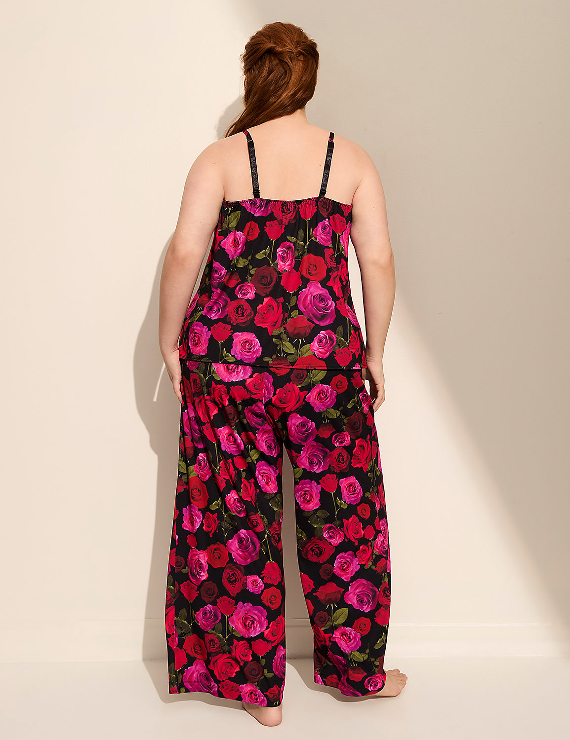 A woman in a floral pajama set stands against a plain, light-colored wall with a shadow cast on it. Product Image 2