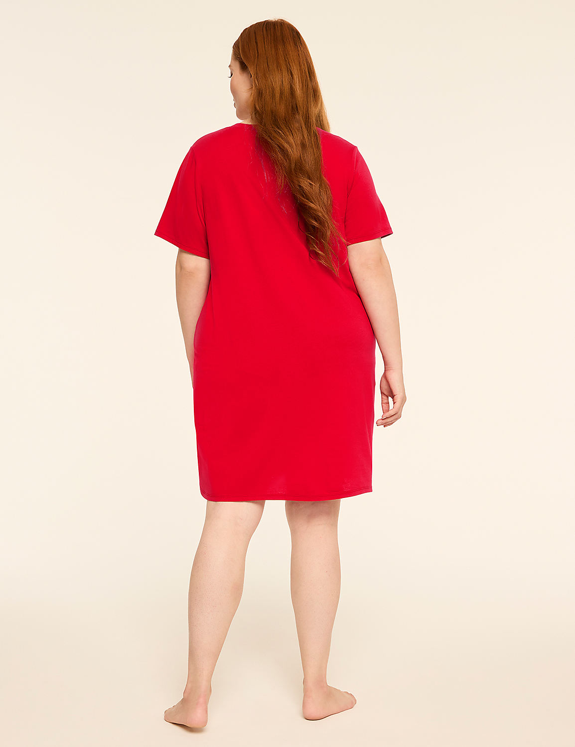 A woman with long red hair stands facing away from the camera in a red t-shirt dress against a plain, light-colored background. Product Image 2