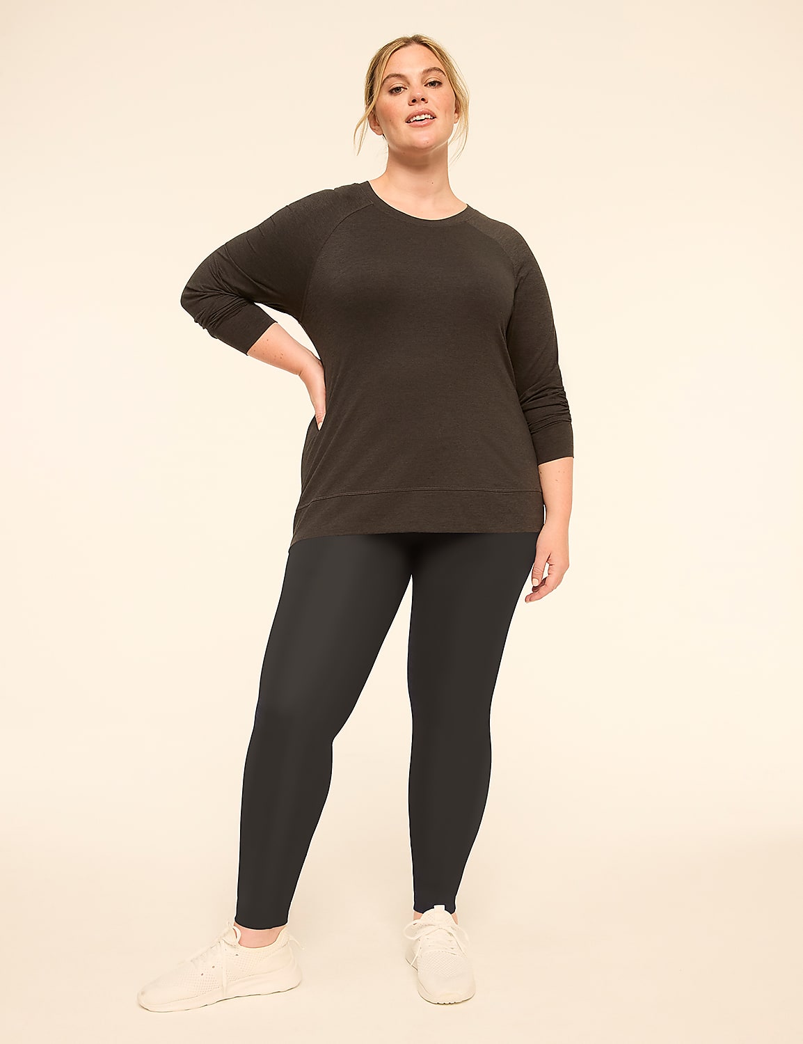 A woman in a dark top and patterned leggings stands against a plain, light-colored background. Product Image 3