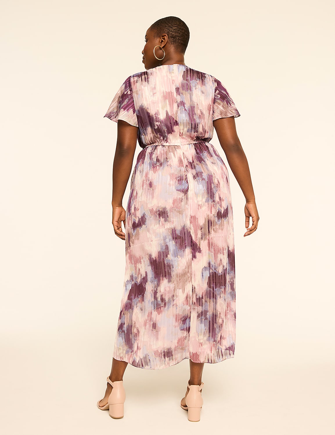 A woman in a floral-patterned dress stands against a plain, light-colored background. Product Image 2
