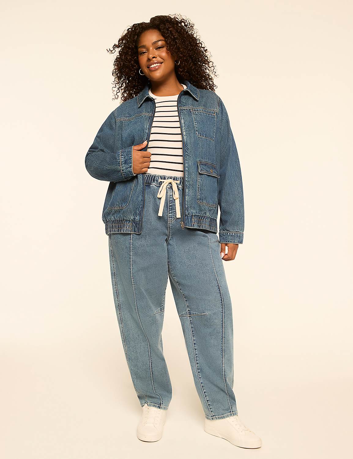 A smiling woman in a denim jacket and pants stands against a plain, light-colored background. Product Image 3