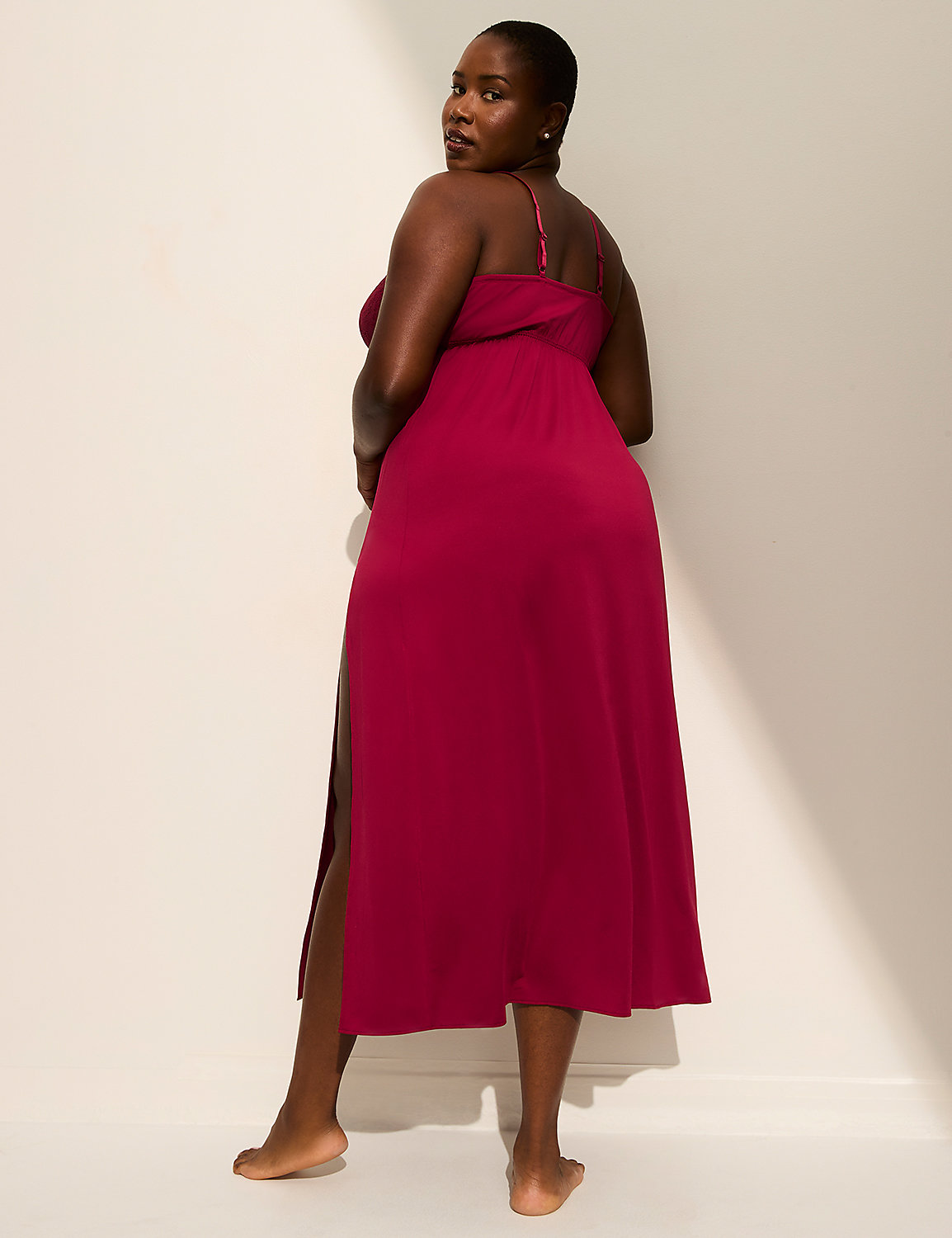A woman in a magenta dress stands against a plain, light-colored wall with a shadow cast on it. Product Image 2