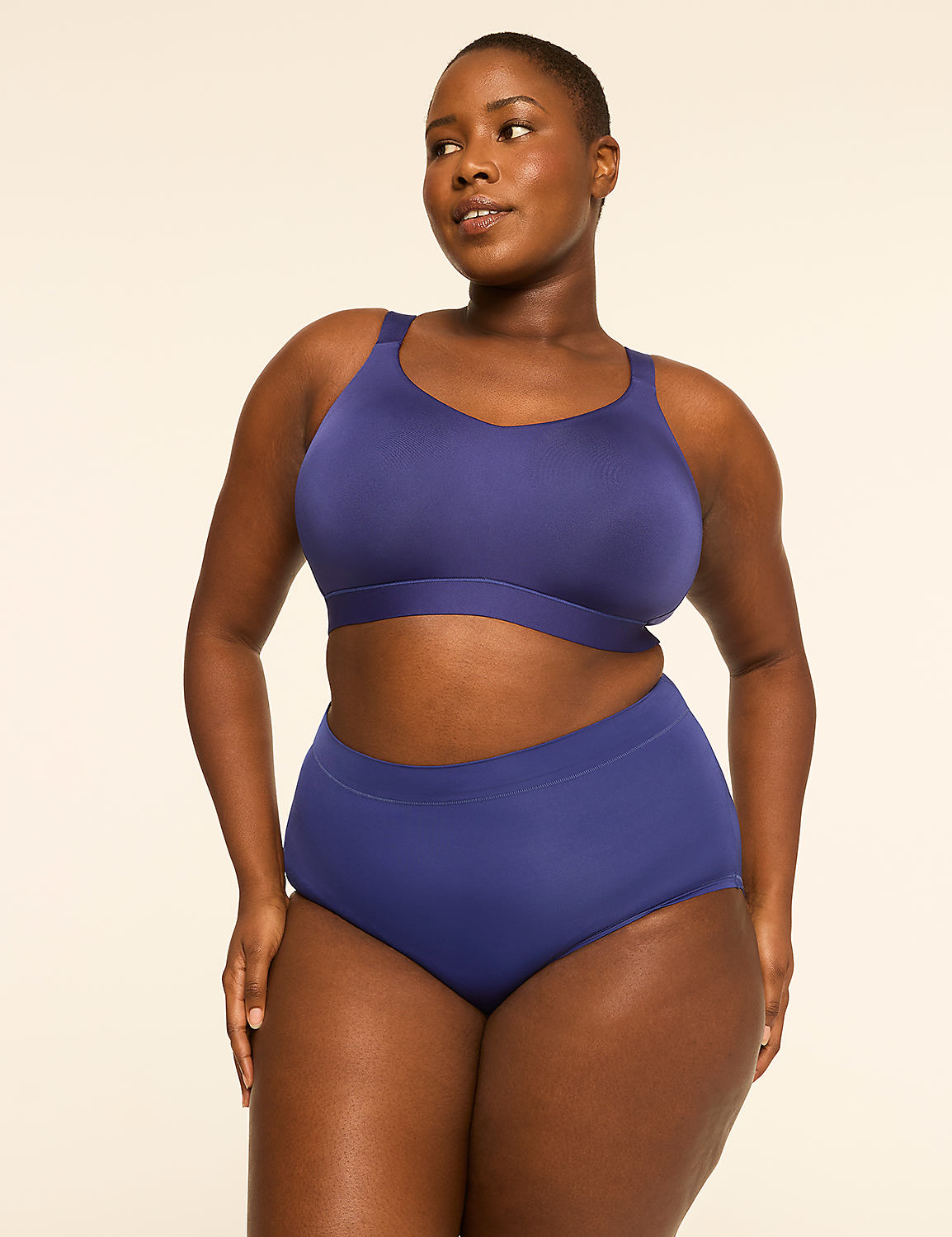 A woman in a navy blue bra and high-waisted underwear stands against a plain, light-colored background. Product Image 4