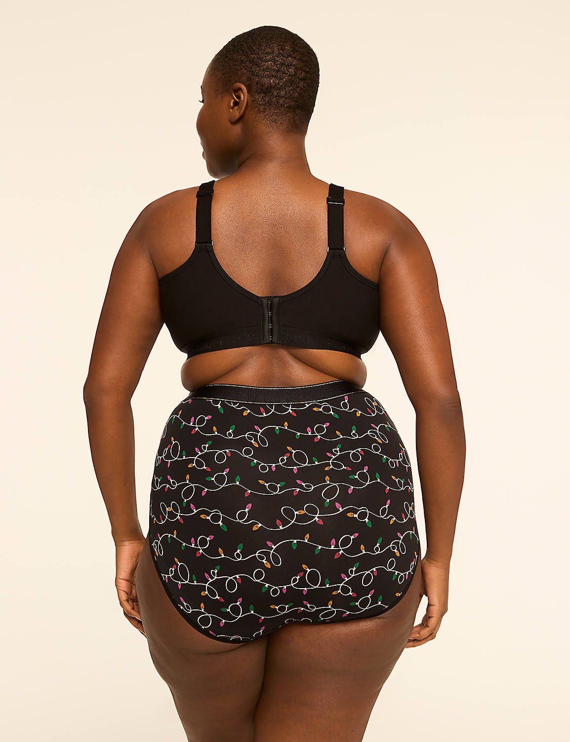 A woman in a black bra and festive patterned underwear stands against a plain, light-colored background. Product Image 2