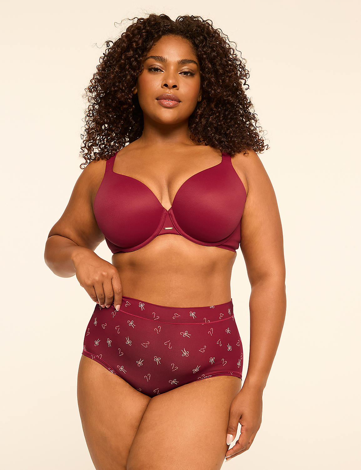 A woman with curly dark hair poses in a maroon bra and matching patterned underwear against a plain, light-colored background. Product Image 4