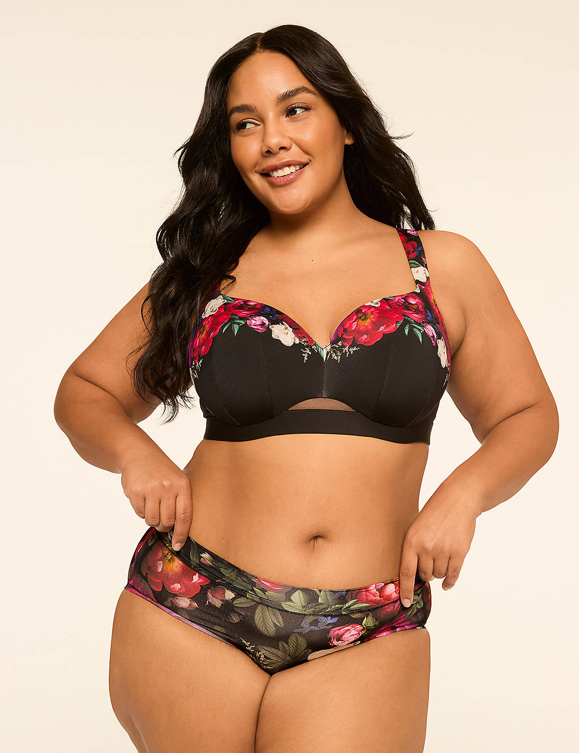 A smiling woman with dark hair poses in a floral bra and matching underwear against a plain, light-colored background. Product Image 4