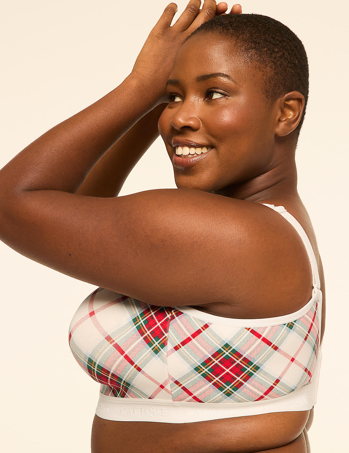 A woman with short hair smiles as she poses with her arms raised, wearing a plaid bra against a plain, light background. Product Image 3