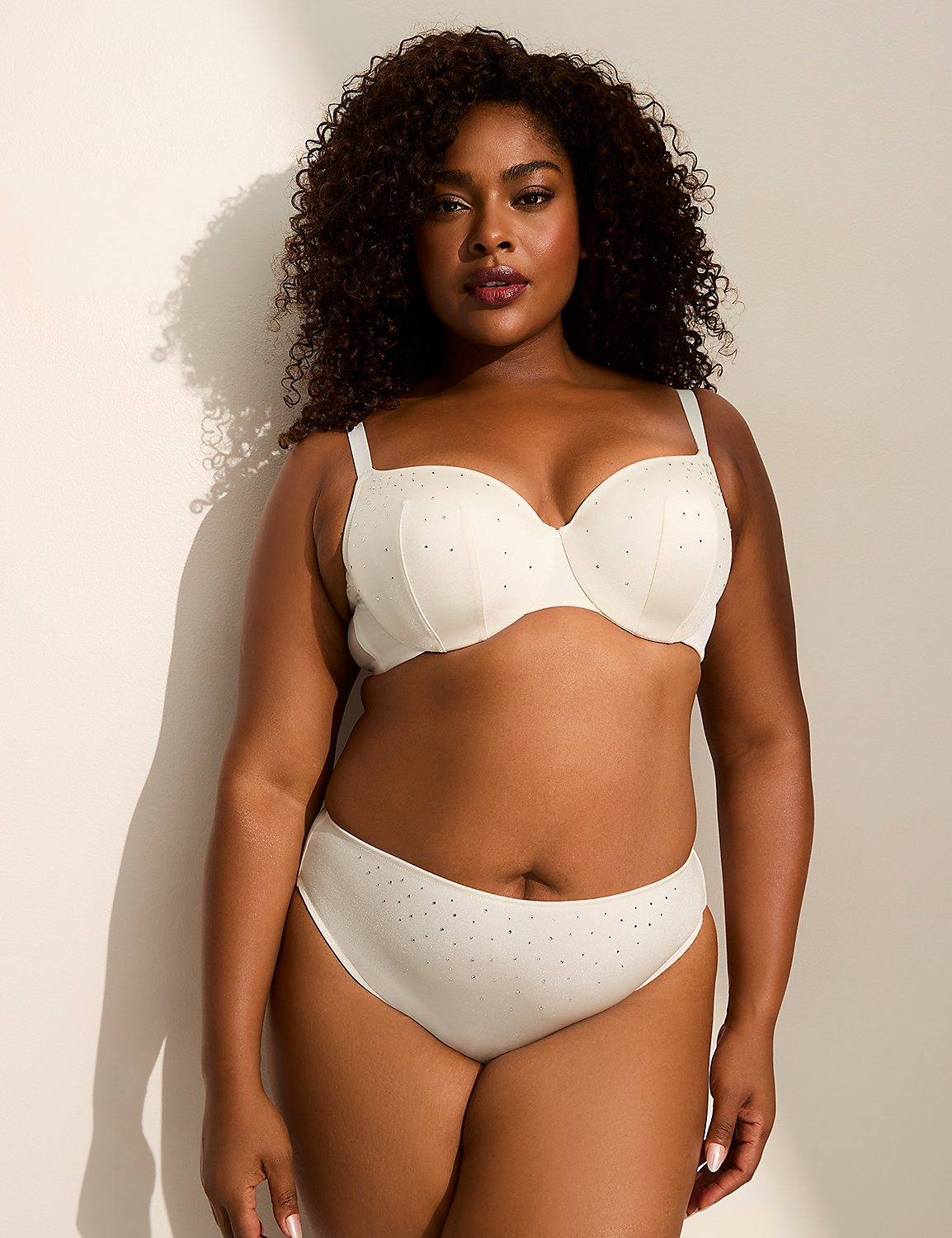 A woman in a cream-colored bra and underwear stands against a plain, light-colored wall with soft shadows. Product Image 4