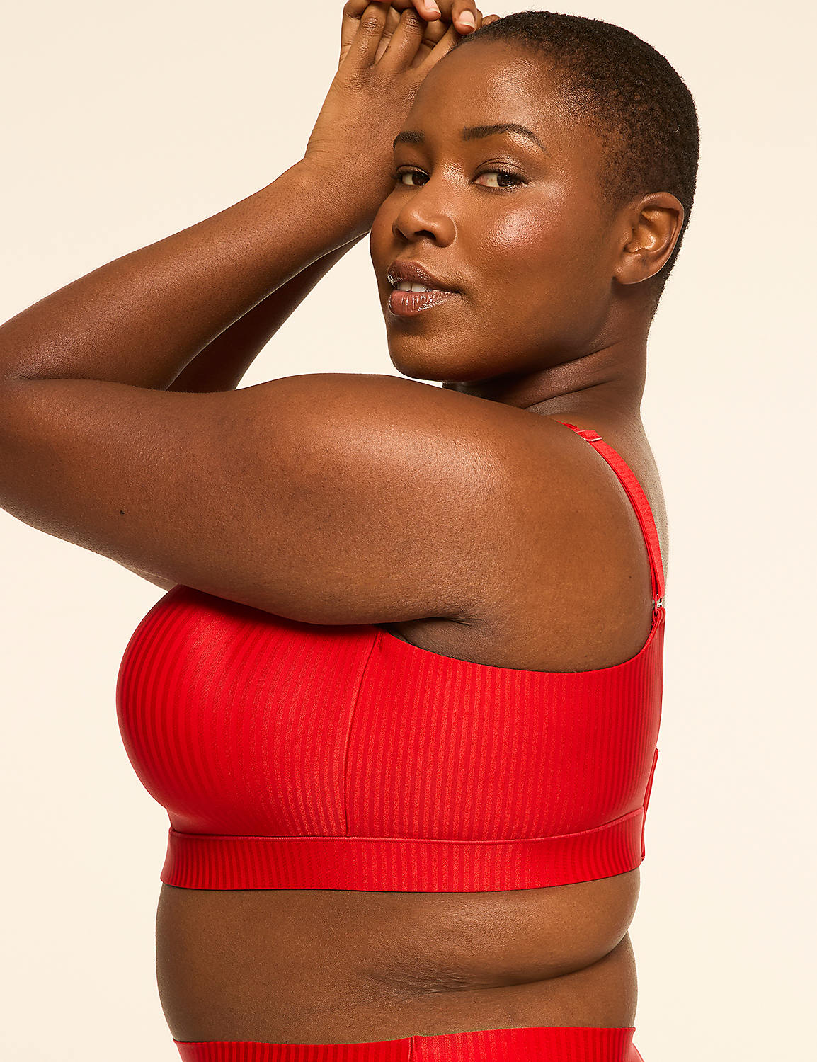 A woman in a red ribbed bikini top poses with her arms raised against a plain, light-colored background. Product Image 3