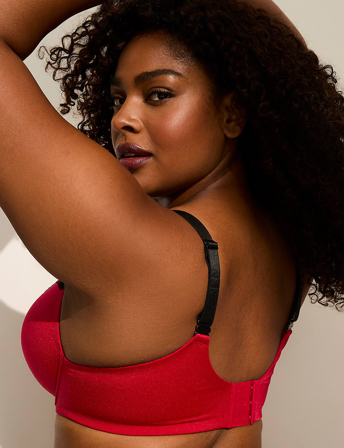 A woman with dark curly hair poses in a red bra against a plain, light-colored background. Product Image 3