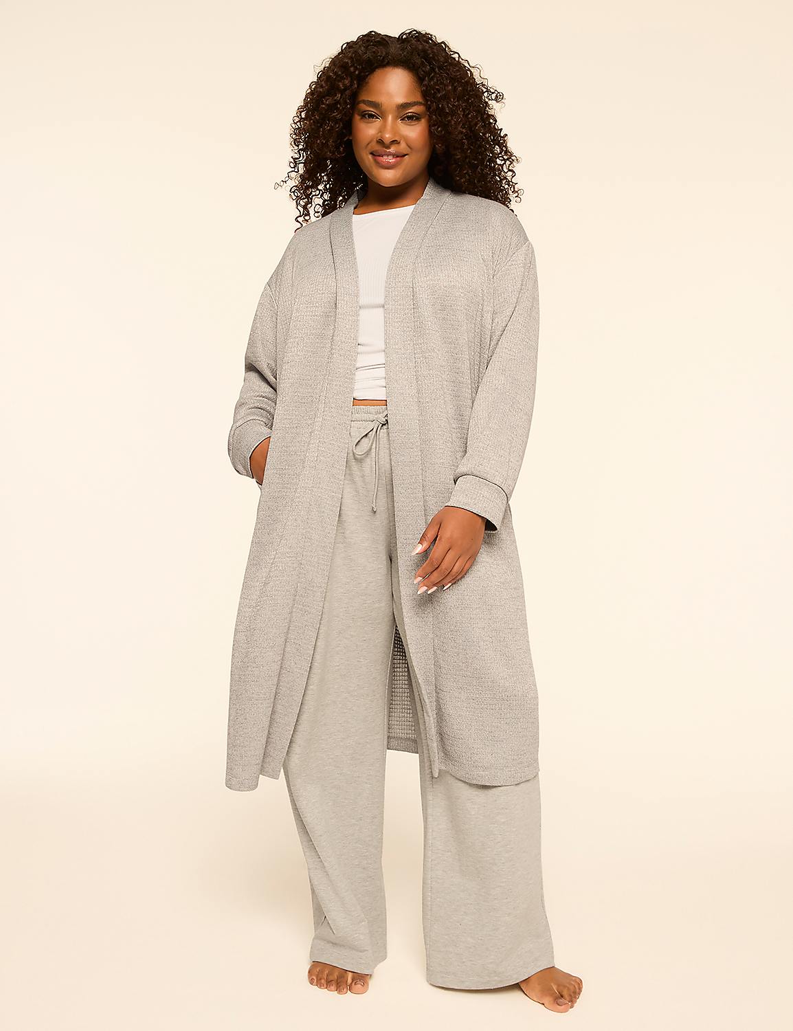 A woman in a grey robe and pants stands against a plain, light-colored background. Product Image 1