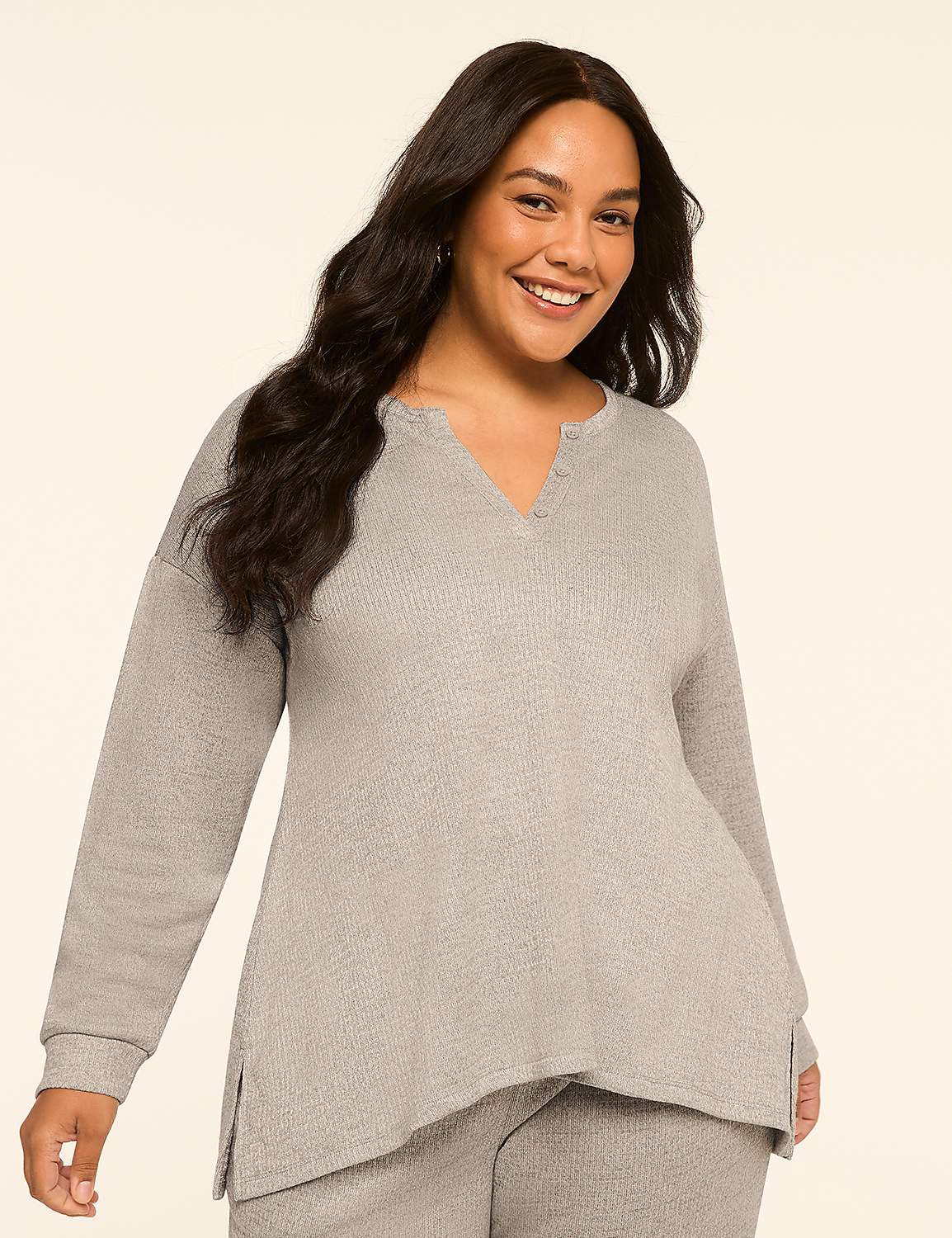 A smiling woman with long, dark hair wears a light gray waffle-knit top and pants against a plain, light beige background. Product Image 1