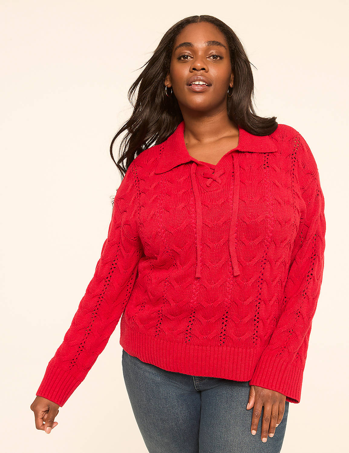 A woman in a red cable-knit sweater and blue jeans stands against a plain, light-colored background. Product Image 1