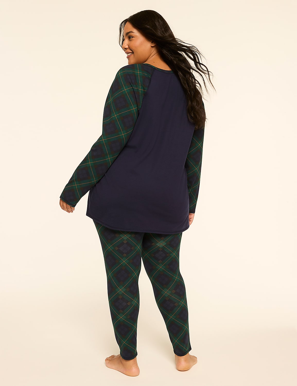 A woman in navy blue pajamas with green plaid sleeves and leggings stands against a plain, light-colored background. Product Image 2