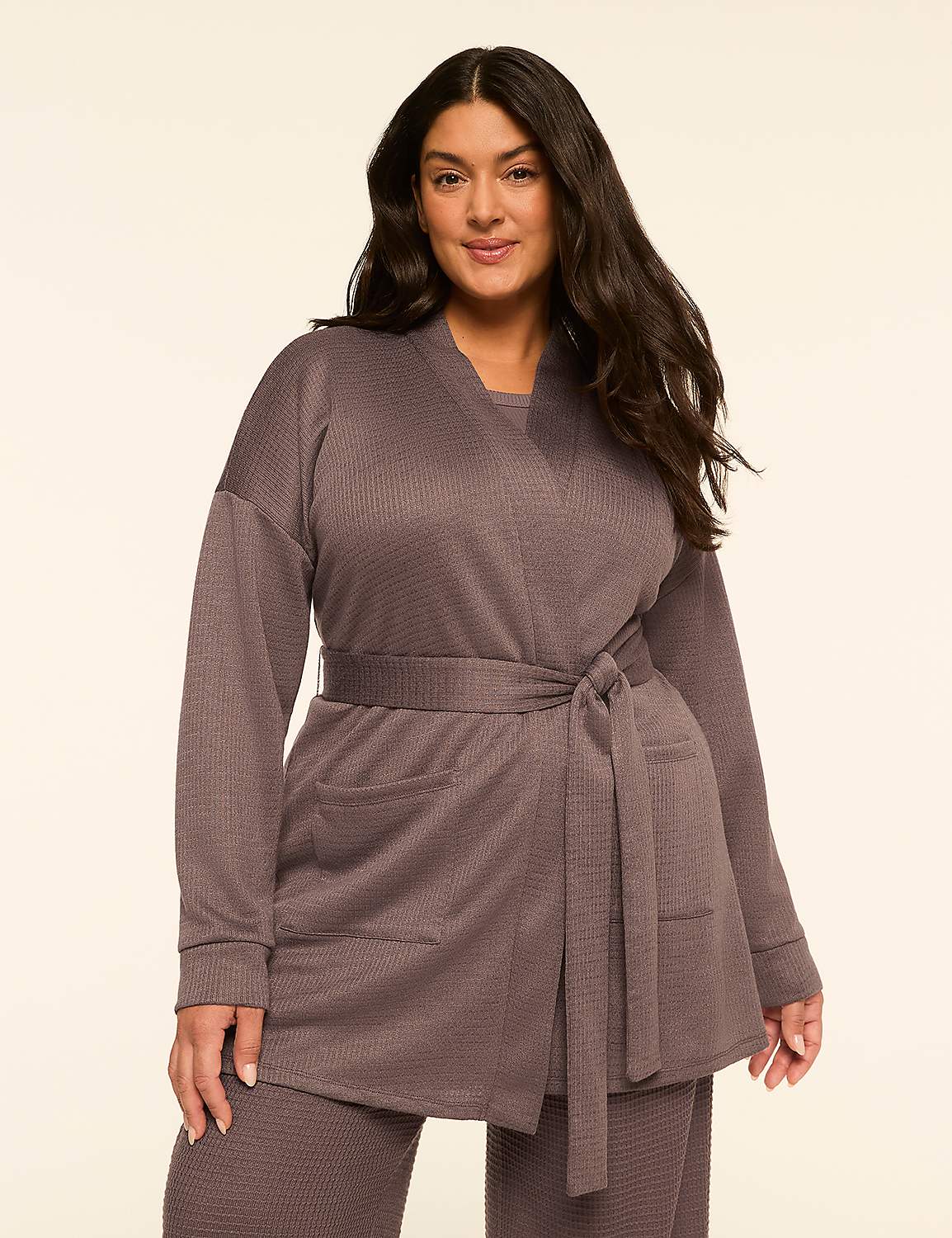A woman in a grey waffle-knit robe with a tie belt stands against a plain, light-colored background. Product Image 1