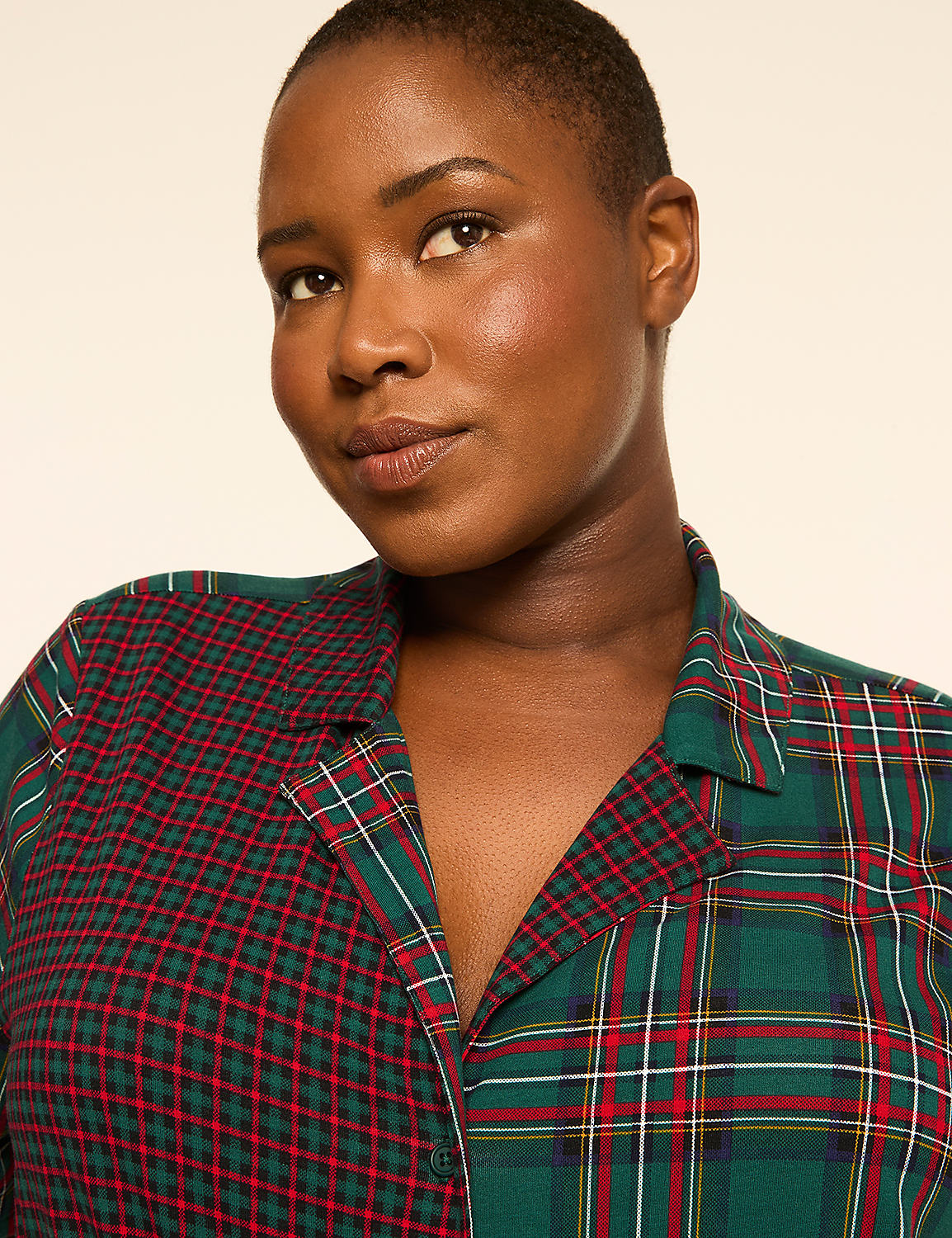 A woman with a short haircut and a plaid shirt is looking at the camera against a plain background. Product Image 4